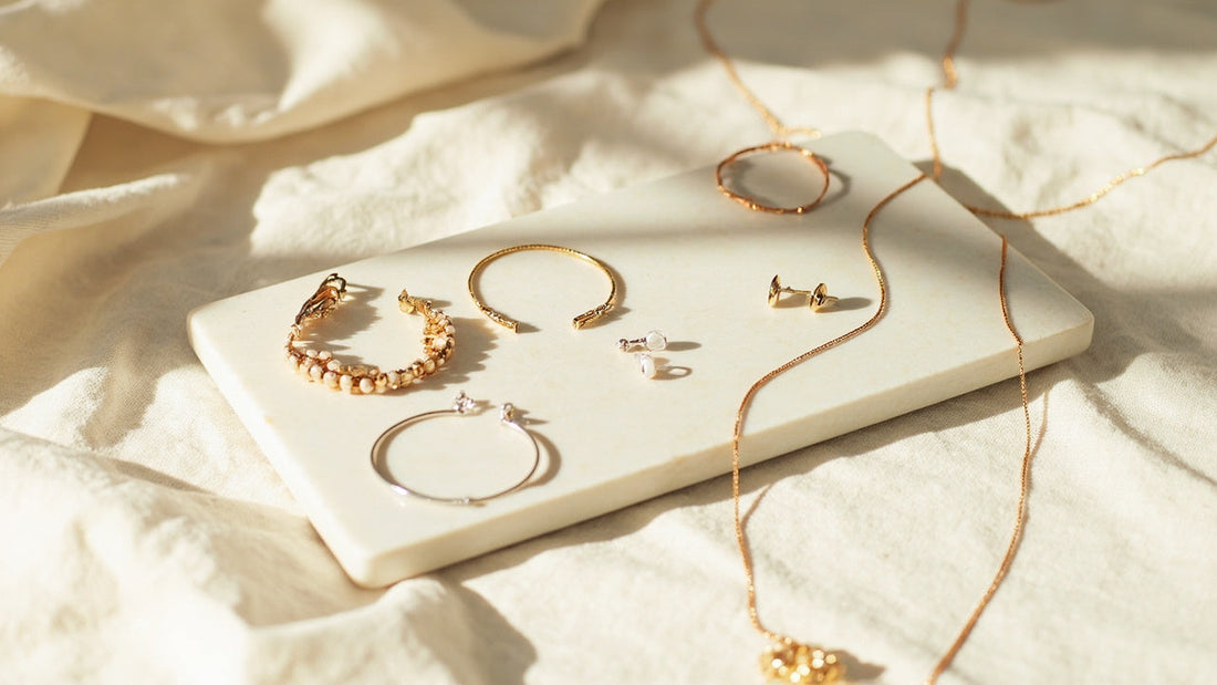 minimal jewelry assortment on stone tray in bright airy window light