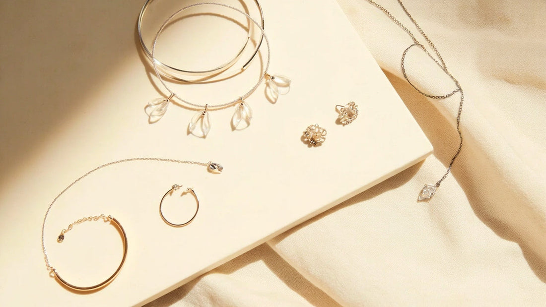 minimalist jewelry flat lay with bracelets earrings and necklace in soft daylight