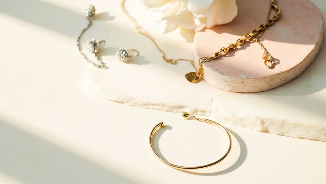 minimalist flat lay of bracelet, earrings, and necklace in soft light