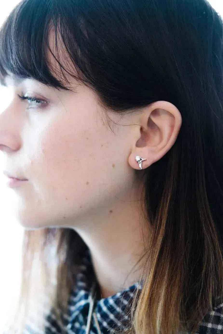 Closeup of woman wearing guardian angel stud earring, jewelry by linhnguyen9